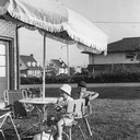 Mack and Sue eating ice cream in the backyard under the new umbrella 1959