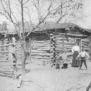 Log house the Redd's stayed in until Ben completed the brick house in 1904.  Photo: Louie, Eva, Louesa and Frank Redd